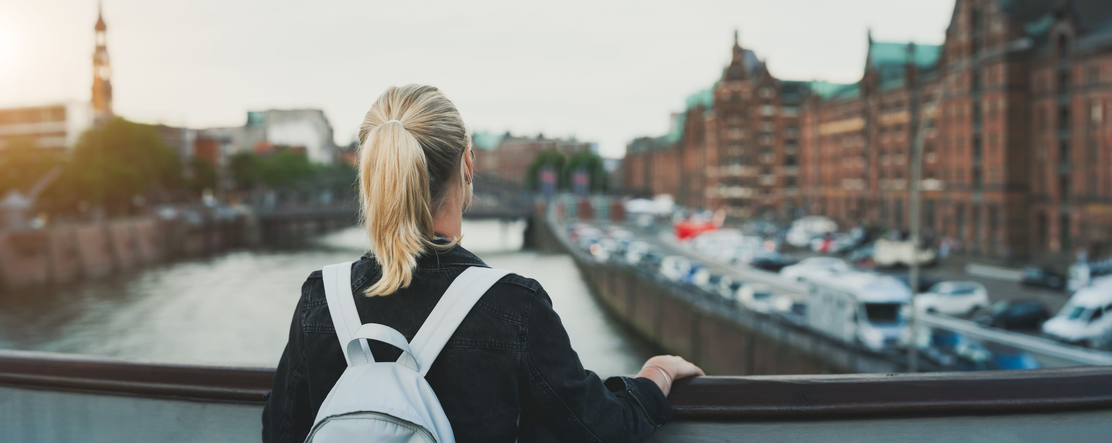 rear-view-woman-with-backpack-standing-by-railing-city (1).jpg